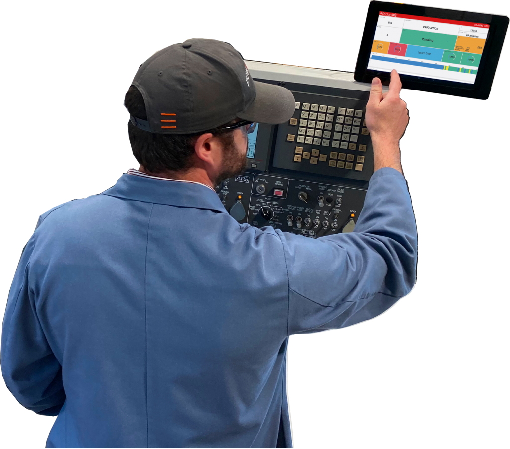 Shop worker standing in front of a machine with a FactoryWiz tablet above it.