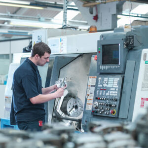 A CNC technician checks measurements