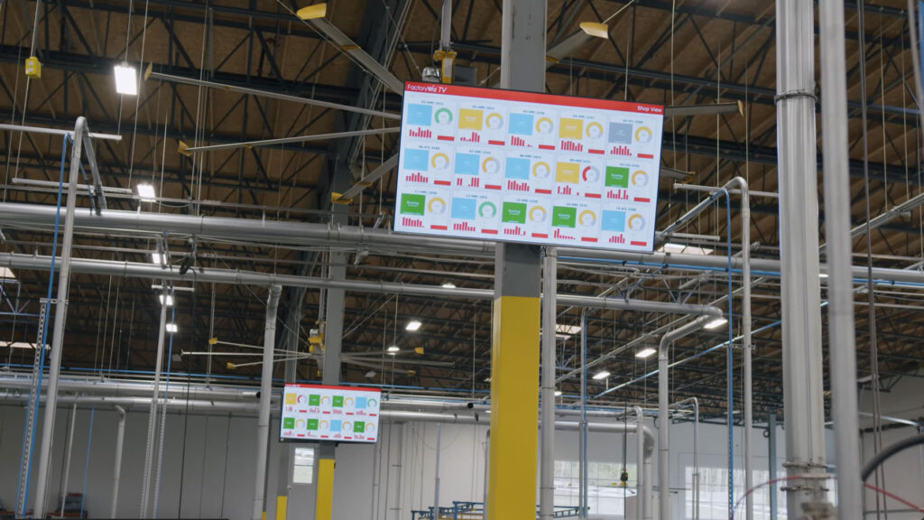 Machine monitoring data displayed on large tv in factory