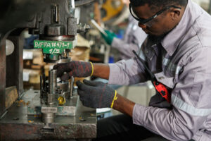 A man wears gloves while operating heavy machinery.